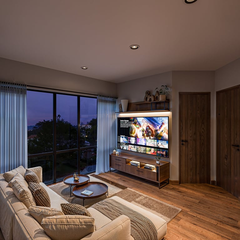 Modern living room with beige sectional sofa, wooden TV console, wall-mounted smart TV, floor-to-ceiling windows with city view at dusk, and hardwood flooring