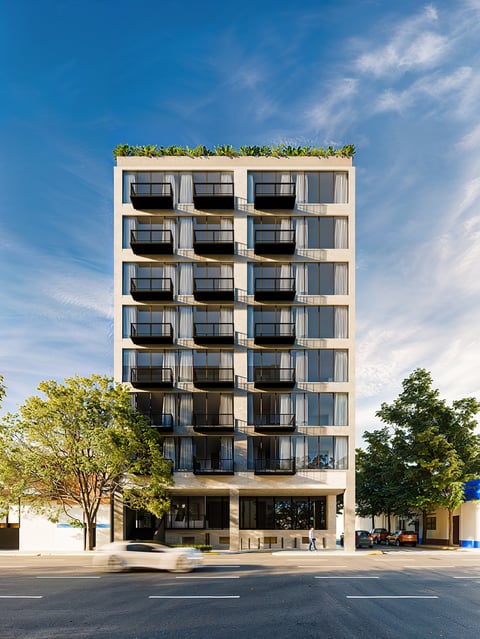 Modern seven-story apartment building with white facade, dark balconies, green rooftop garden, and ground-level retail, surrounded by trees