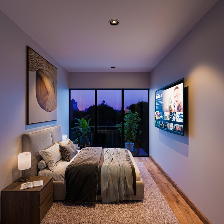 Modern bedroom with bed, nightstand, framed artwork on walls, TV, large windows with evening city view, and ambient lighting