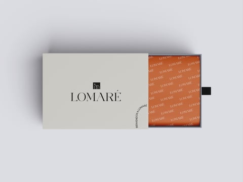 Empaque de marca de lujo Lomaré con sobre crema y caja con patrón naranja sobre fondo gris