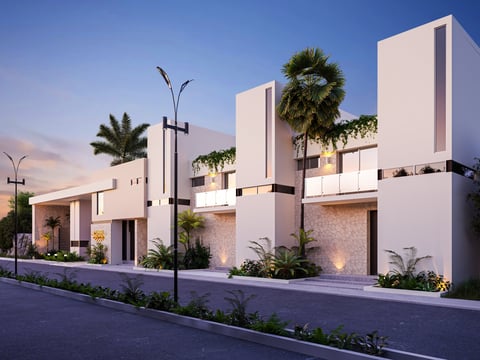 Modern white townhouses with geometric architecture, palm trees, and landscape lighting at dusk