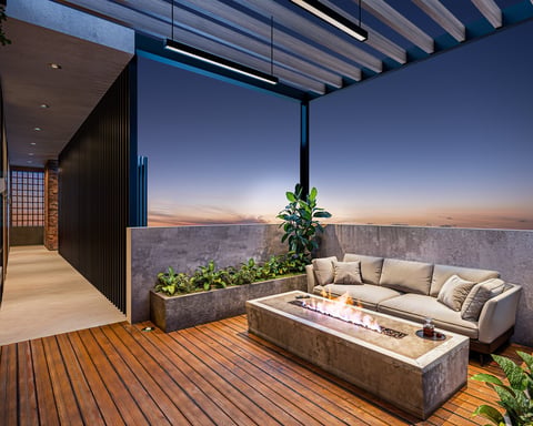 Modern rooftop terrace with seating, fire pit, and sunset city view at dusk