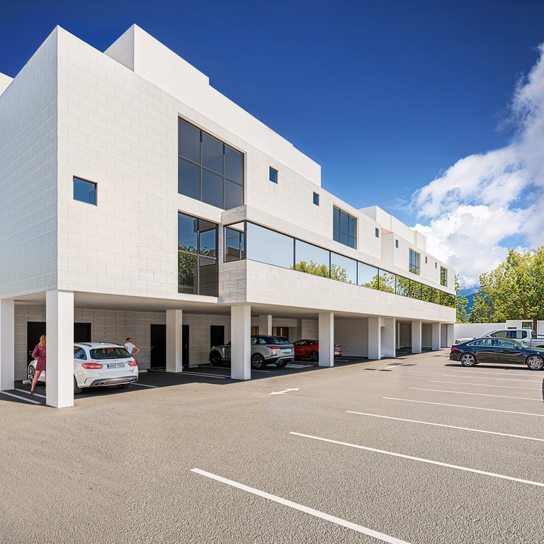 Modern white residential building with ground-floor garage parking and vehicles parked beneath covered carport area