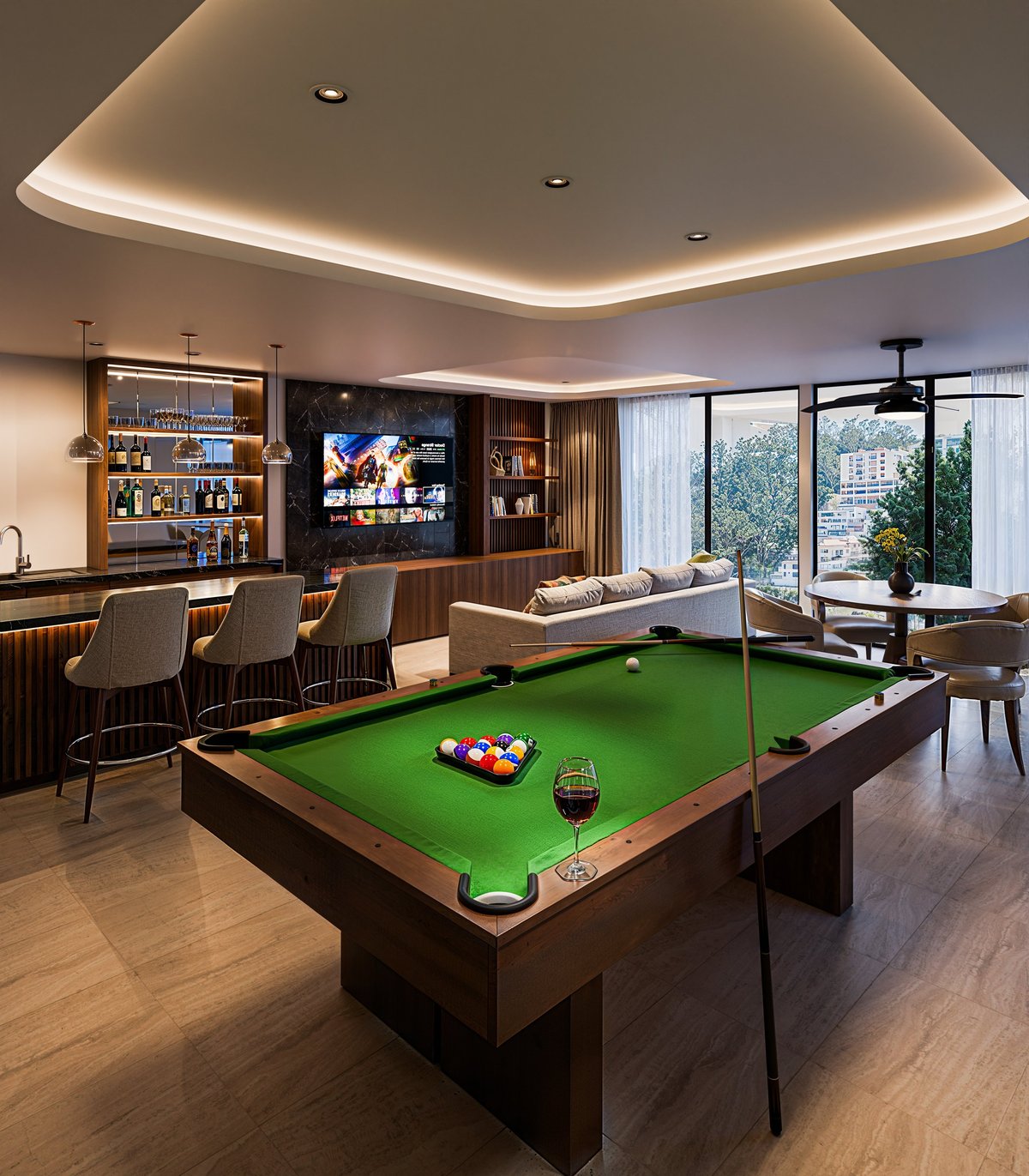 Modern luxury game room with green billiards table, wet bar, ambient ceiling lights, and panoramic windows overlooking city views.
